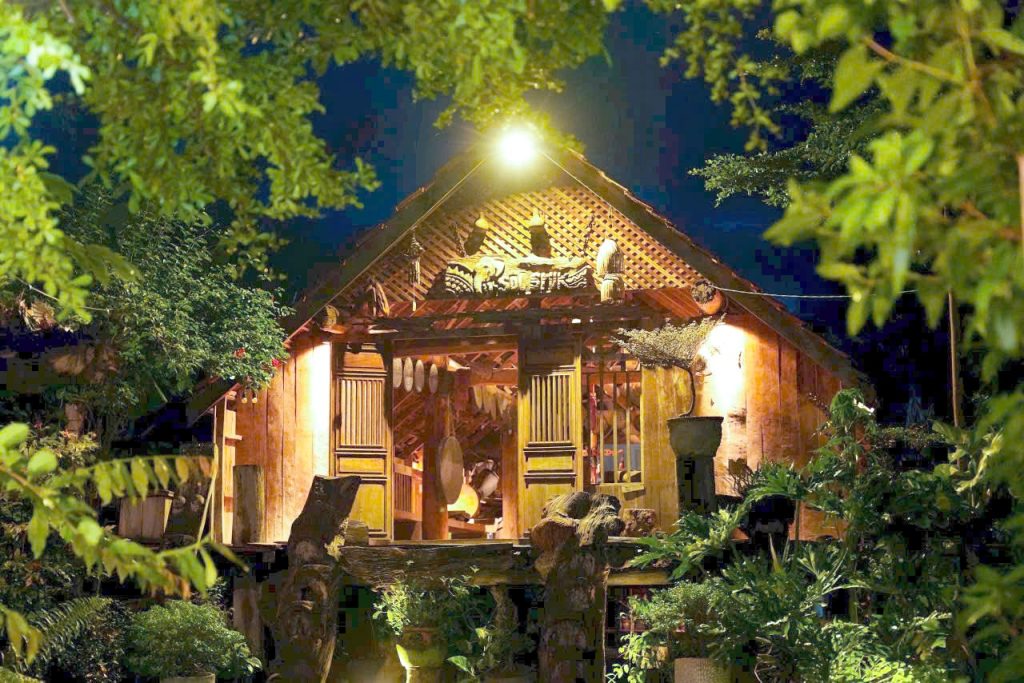 Wooden stilt house lit up at night near Lak Lake
