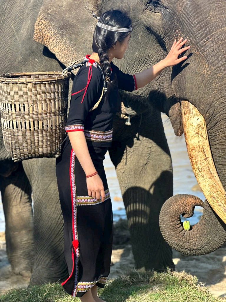M'nong woman in traditional dress with an elephant at Lak Lake