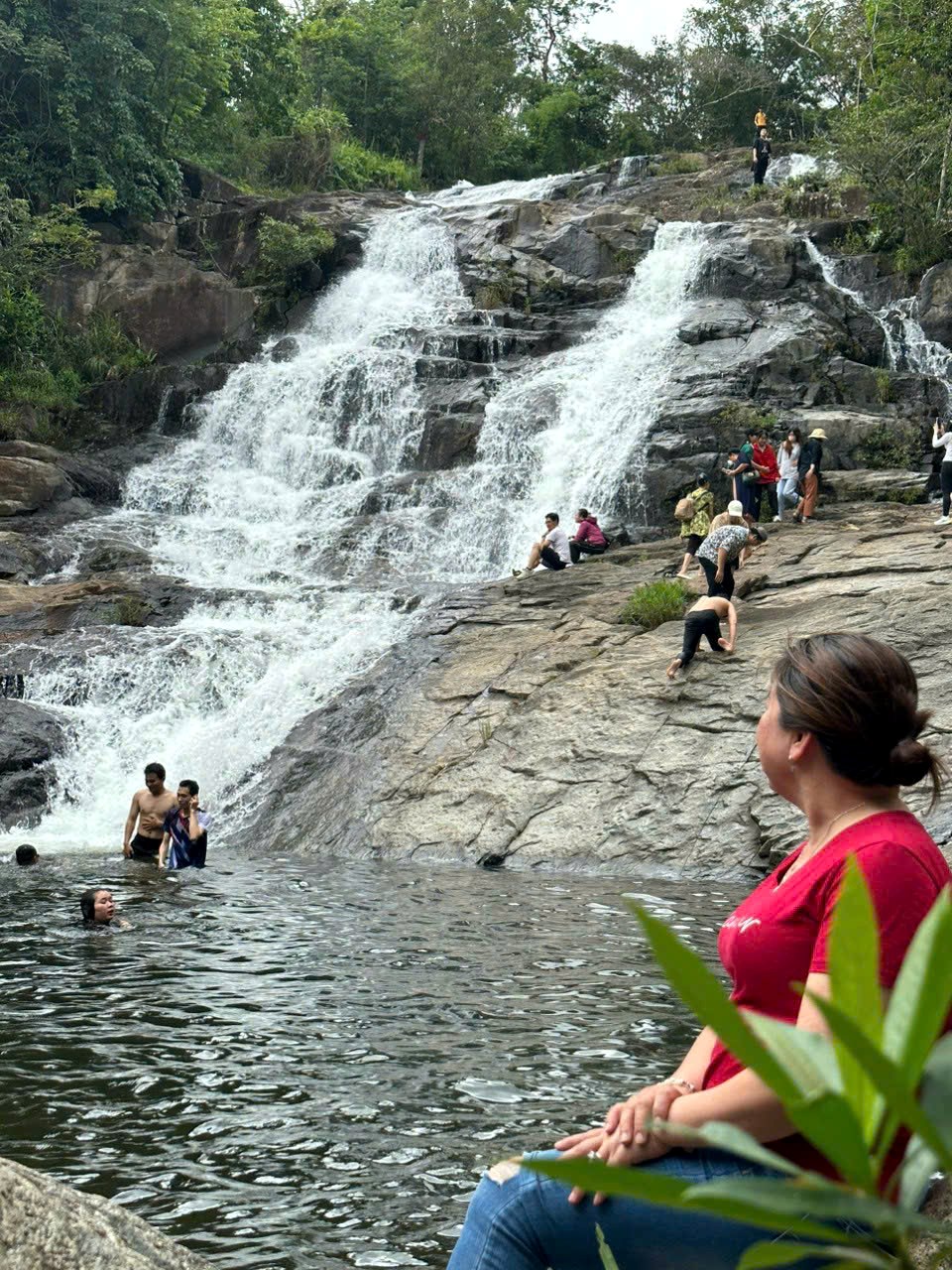 Visitors at a forest waterfall near Lak Lake
