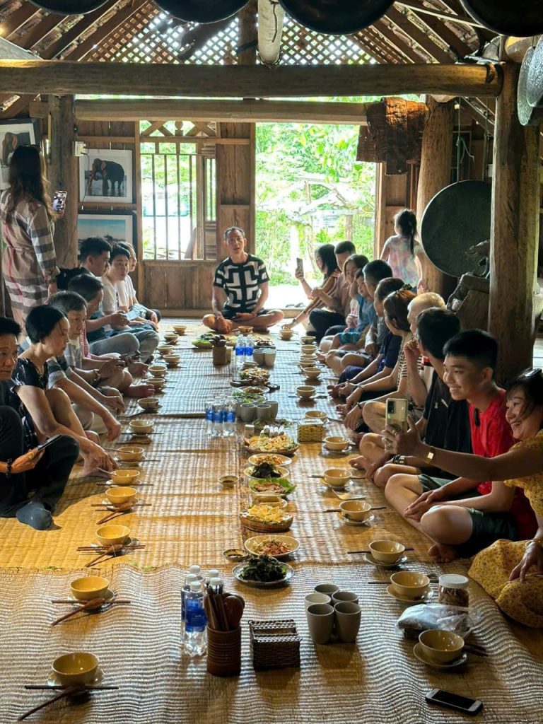 Group dinner at a long table inside a stilt house
