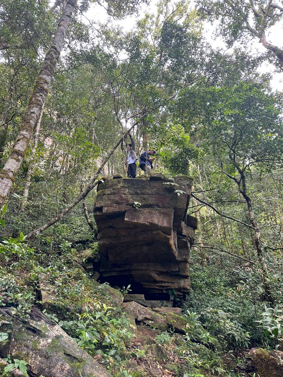 Trekkers on a rock pillar in the forest of Chu Yang Lak