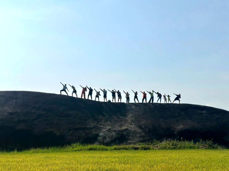 Trekking group celebrating on a rocky ridge of Chu Yang Lak